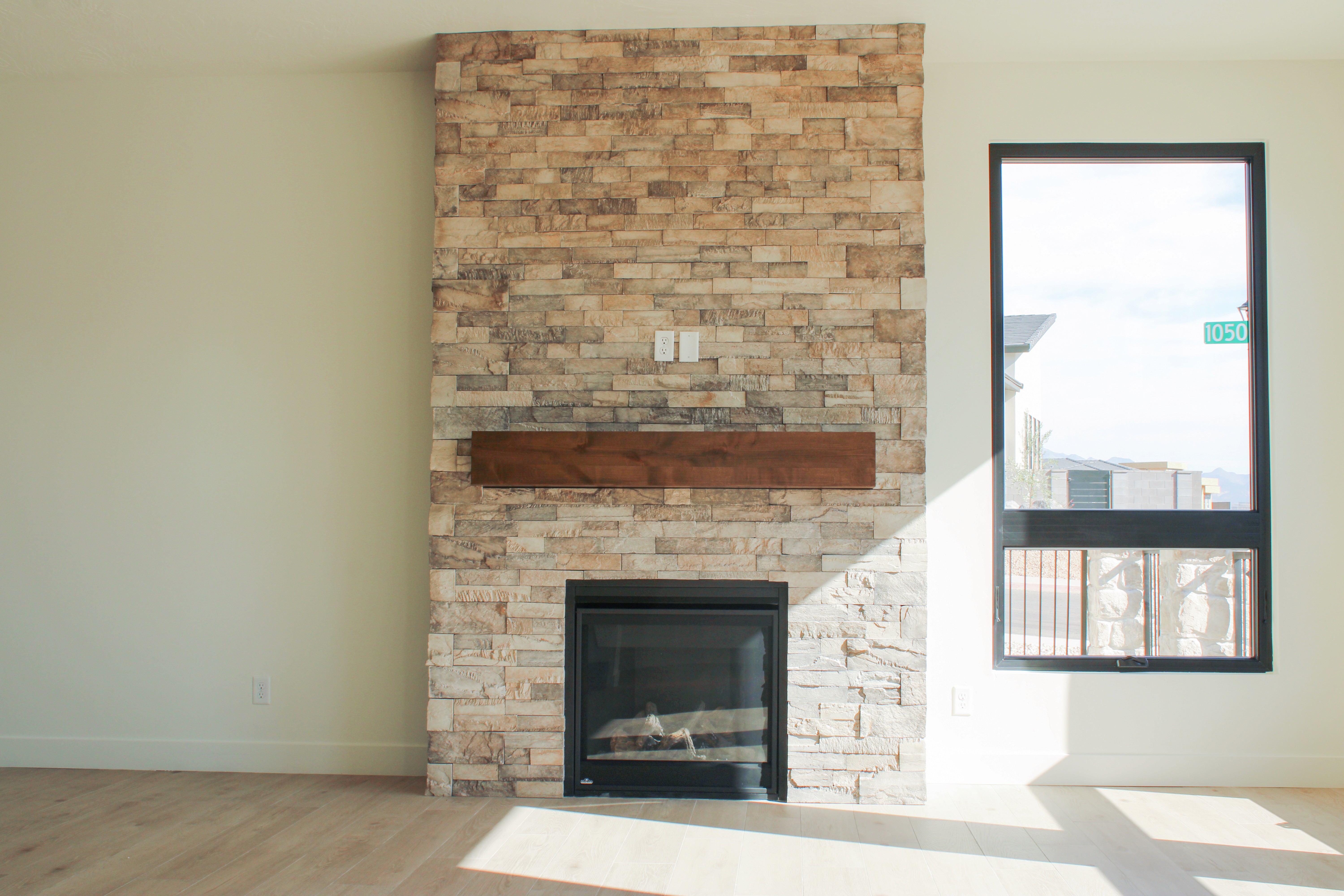 Stone fireplace in the living room of The Overlook at Falcon Ridge in Hurricane, Utah, featuring floor-to-ceiling masonry and a custom mantel.