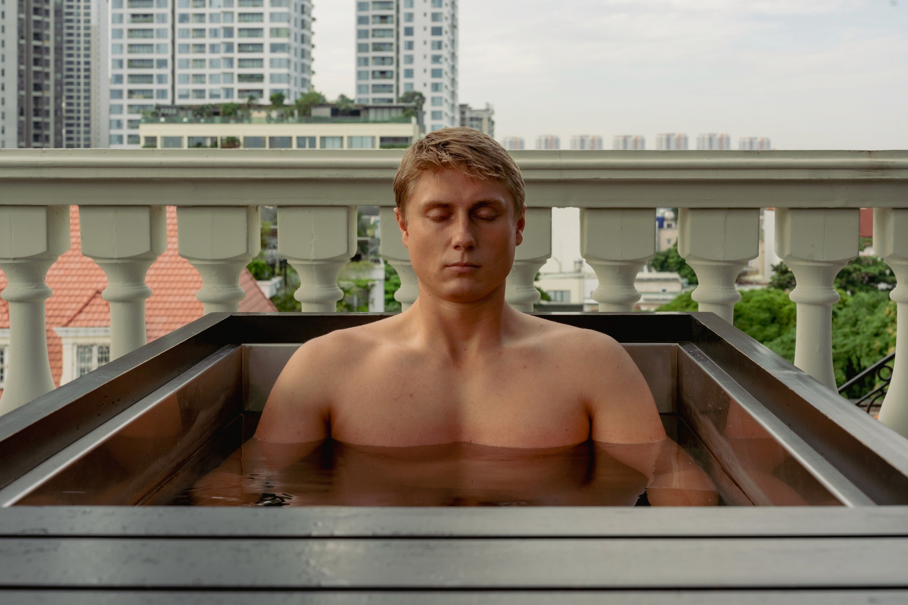 A person relaxes in a luxurious spa bath filled with rich, earthy water, embodying a sense of tranquility and wellness, promoting the concept of premium fitness and spa rejuvenation.