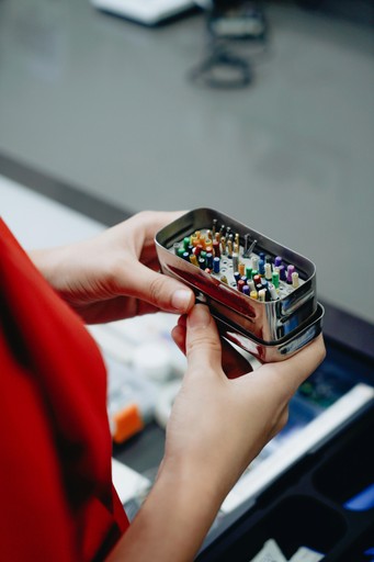 Person holding a box of endodontic treatment hand files