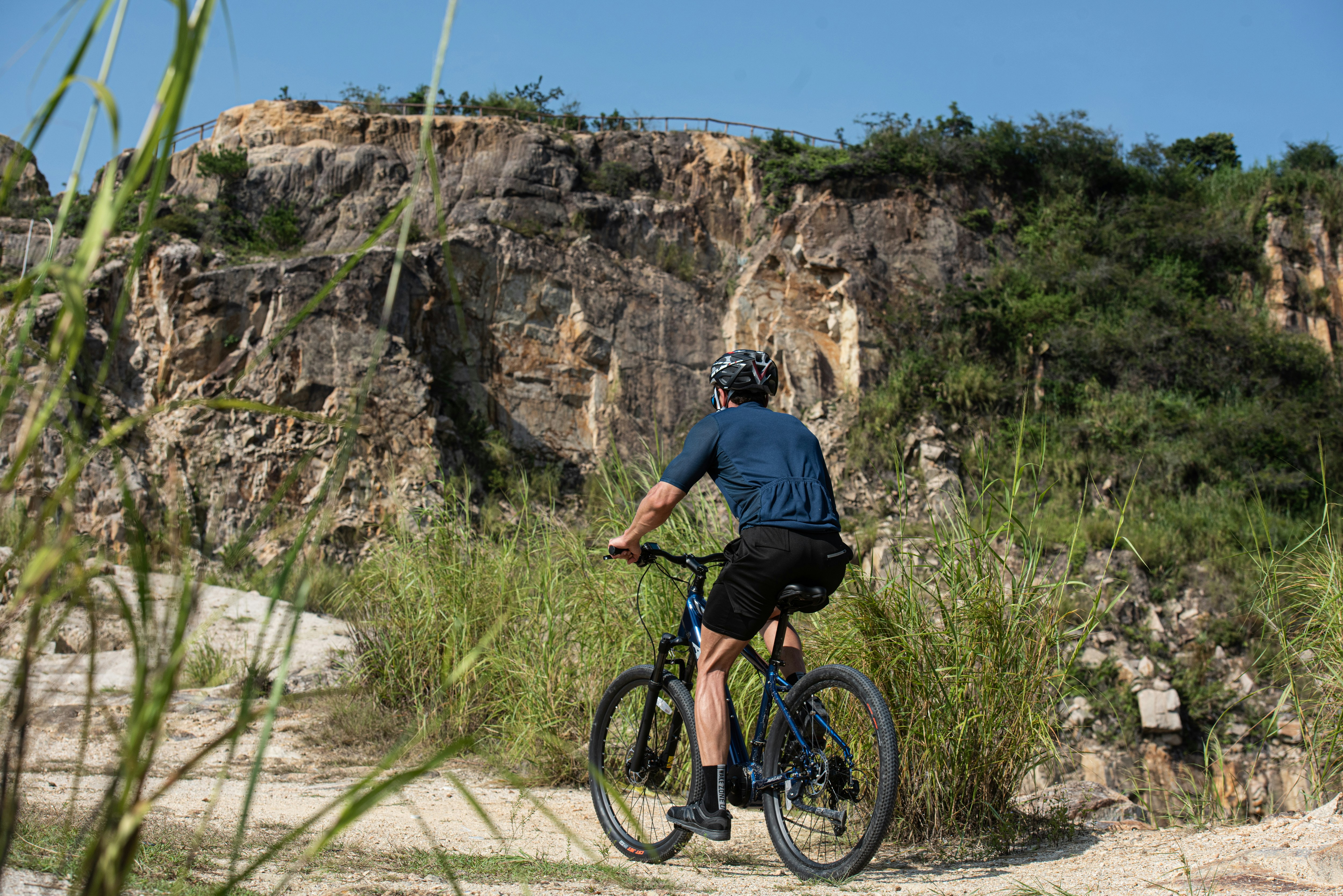 a man riding a bike down a dirt road