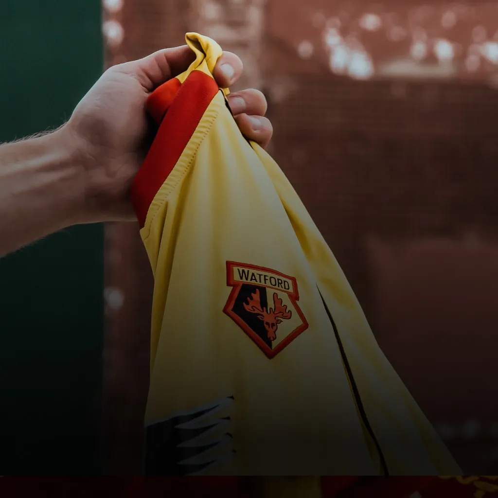 Image of hand holding retro Watford FC football shirt for KitLegit