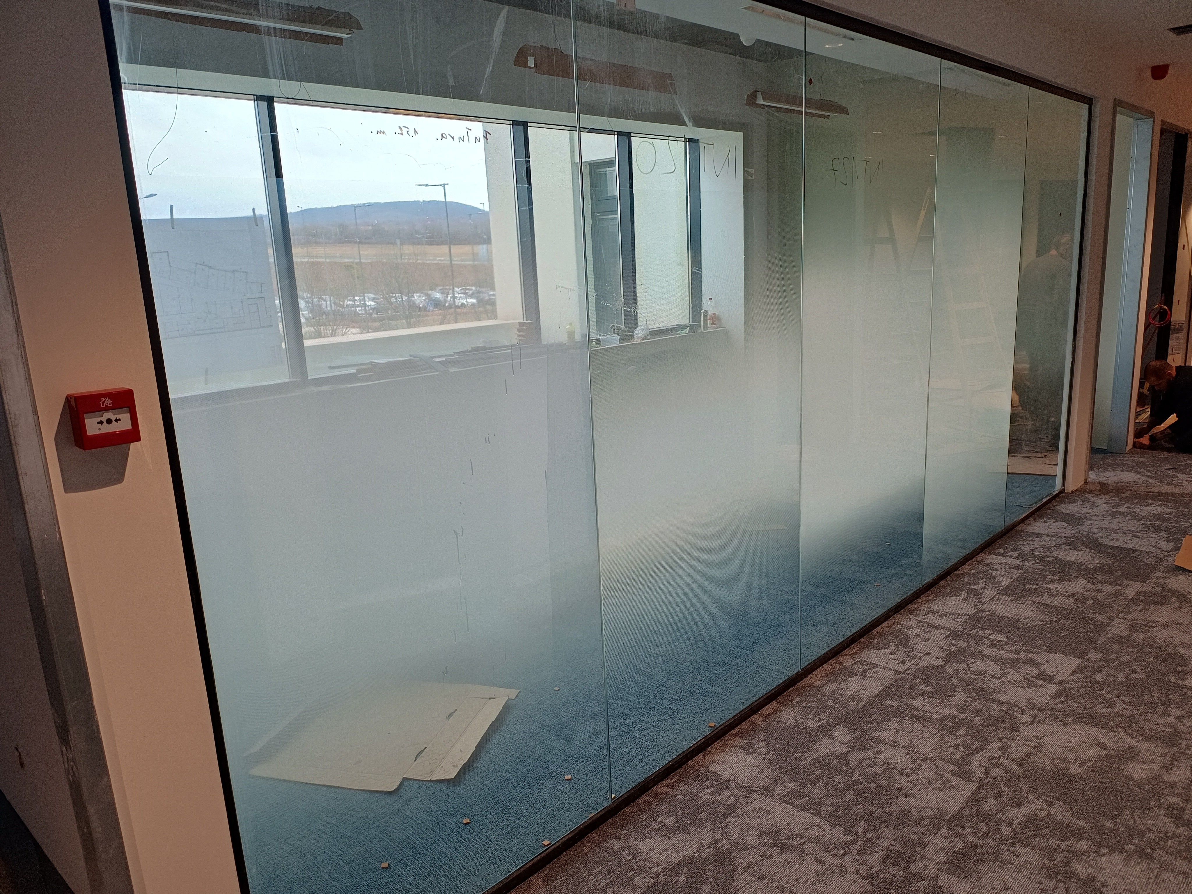 Átmenetes, más néven gradient belátásgátló ablakfólia telepítése irodai üvegfalakra. Az alulról felfelé fokozatosan halványodó tejüveg hatás elegáns belátásvédelmet nyújt, miközben átengedi a fényt.