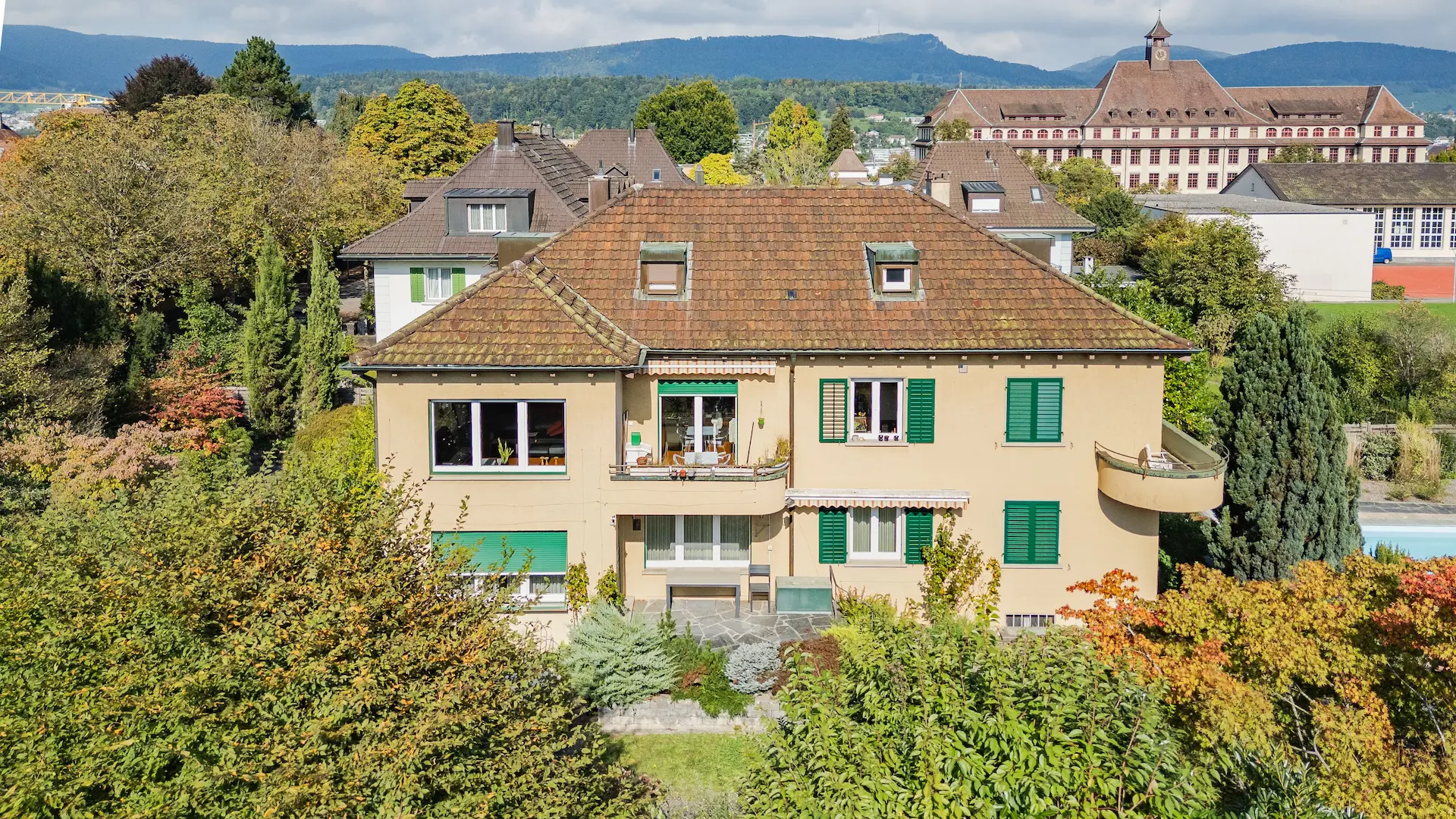 Drohnenaufnahme eines historischen Herrenhaus mit charakter, umgeben von Bäumem