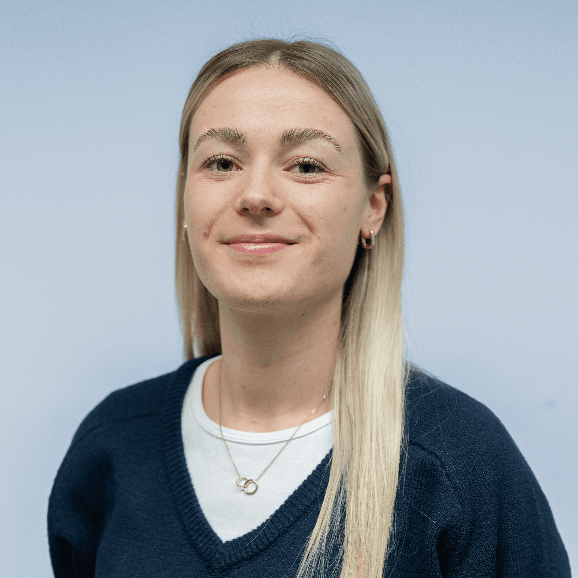 Portrait of a laughing person with curly hair wearing a white shirt
