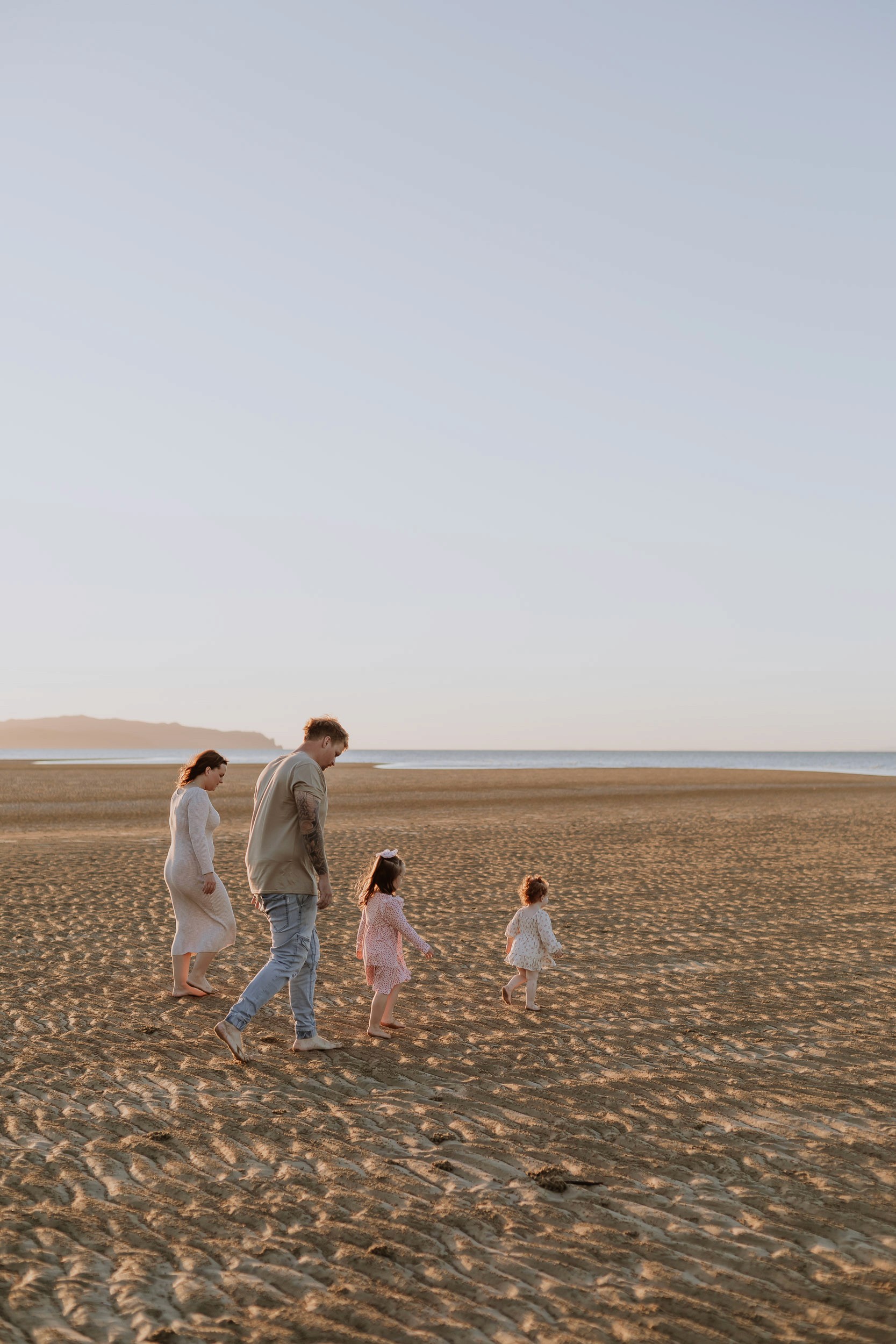 Parents and children walking along the beach in Mackay