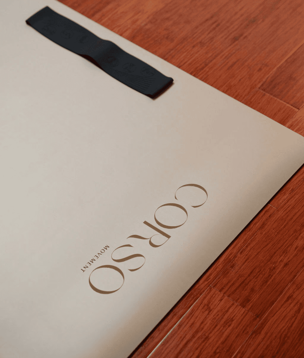 Close-up of hands holding a small glass bottle with a liquid skincare product, against a soft, blurred background