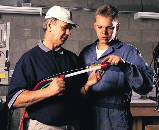 Two men holding a cartridge gun