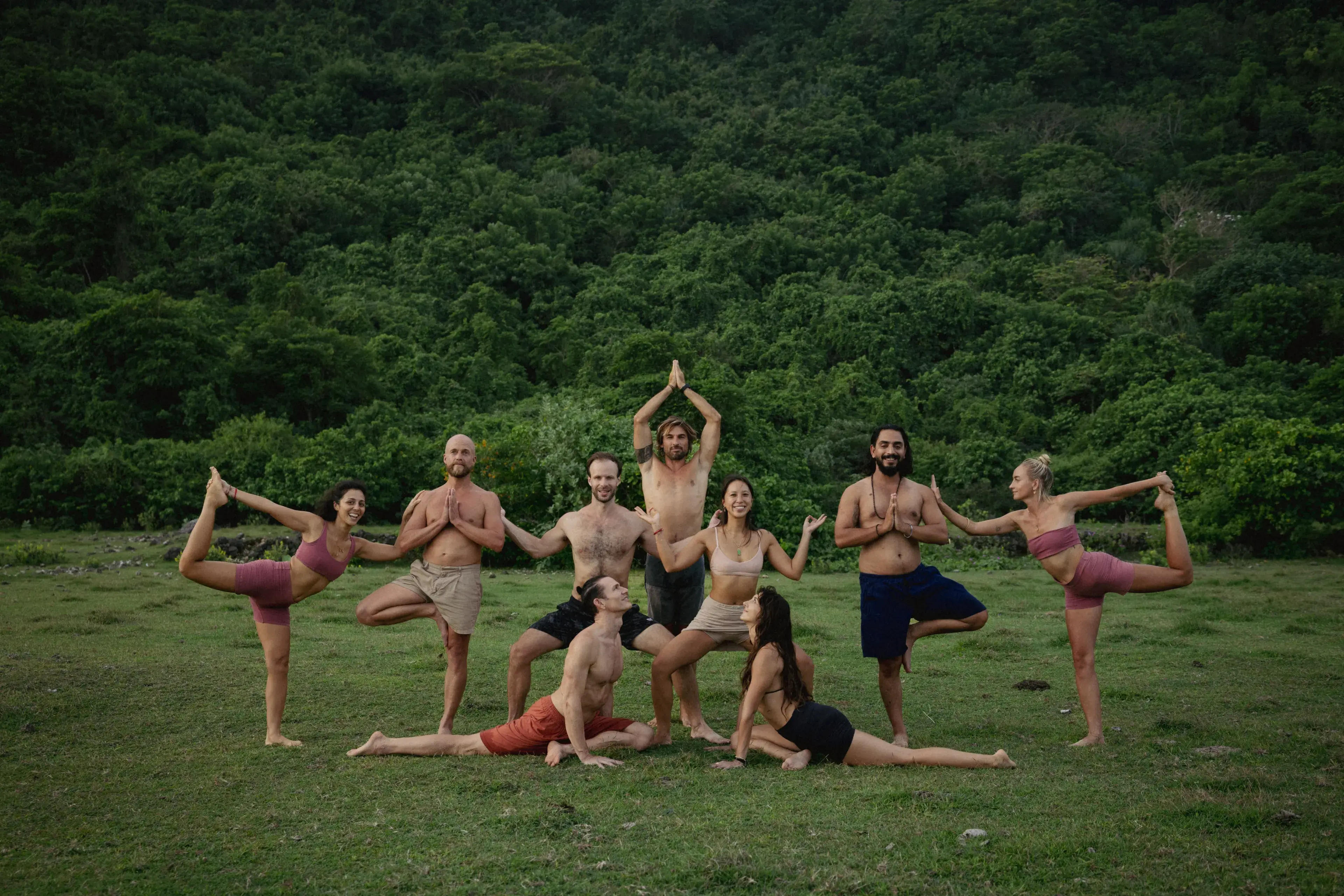 Group of yoga teacher training students practicing outdoor asanas together in Bali's lush tropical nature