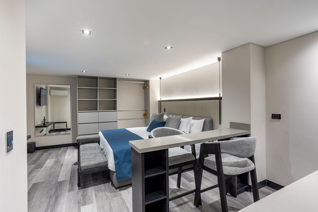 Hotel residencial premium Medellín, suite Altus Comfort con cocina privada, barra americana y vestier para máxima comodidad en estadías prolongadas.