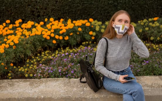 Дівчина у масці на тлі квітів