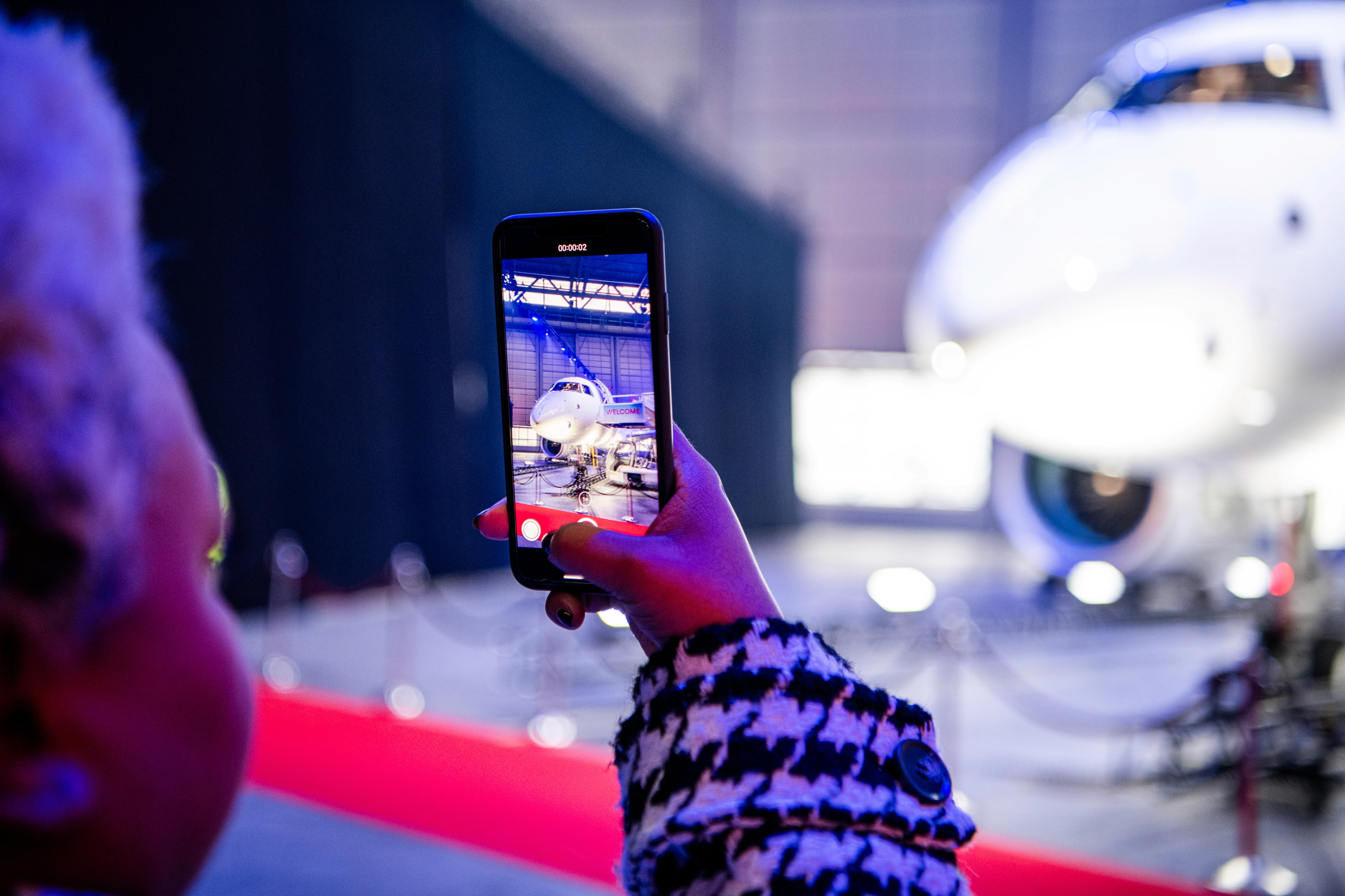 Attendee photographing the Embraer E190-E2 during the launch event