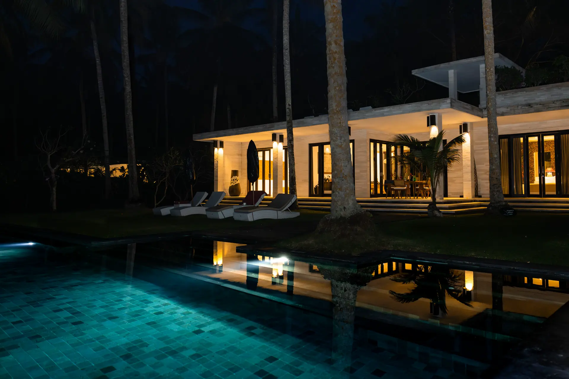 Luxus-Villa mit Poolbeleuchtung bei Nacht – Elegante Architektur des Kelapa Retreat & Spa Resorts auf Bali