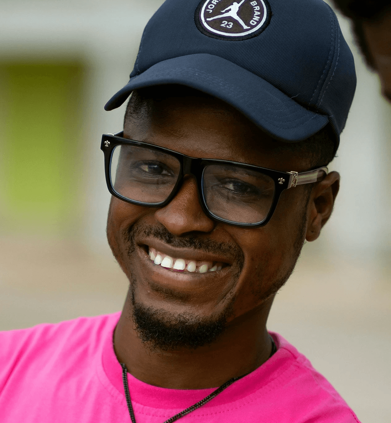 a man in a pink shirt and a black hat