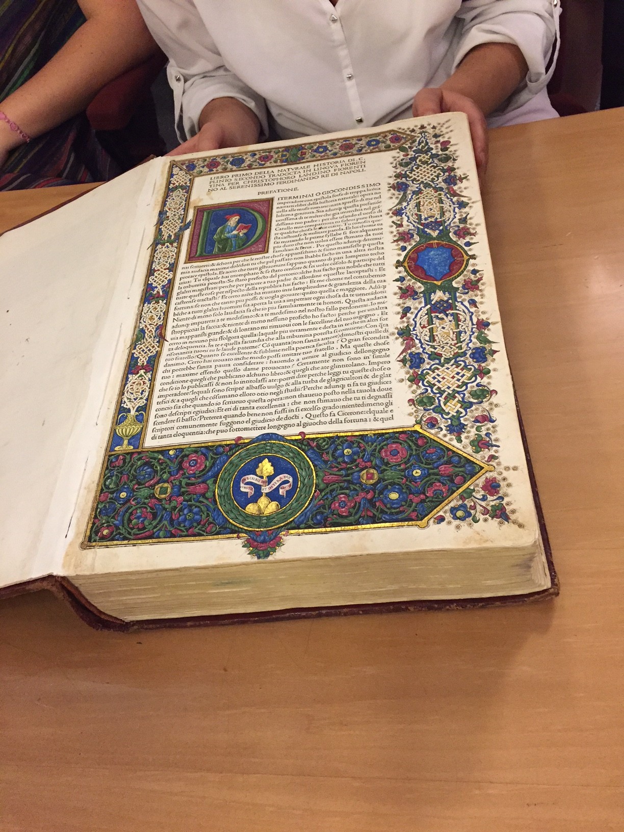 Old book with text surrounded by colorful artwork and drawings.