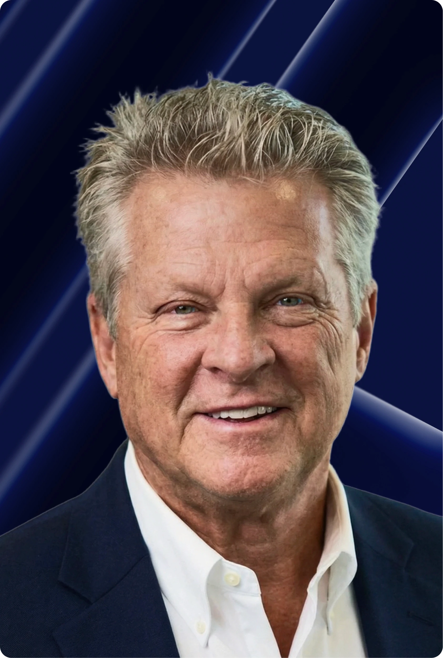 Close-up portrait of a person wearing a gray insulated hooded jacket with the hood up, showing their face framed by the hood against a light background.