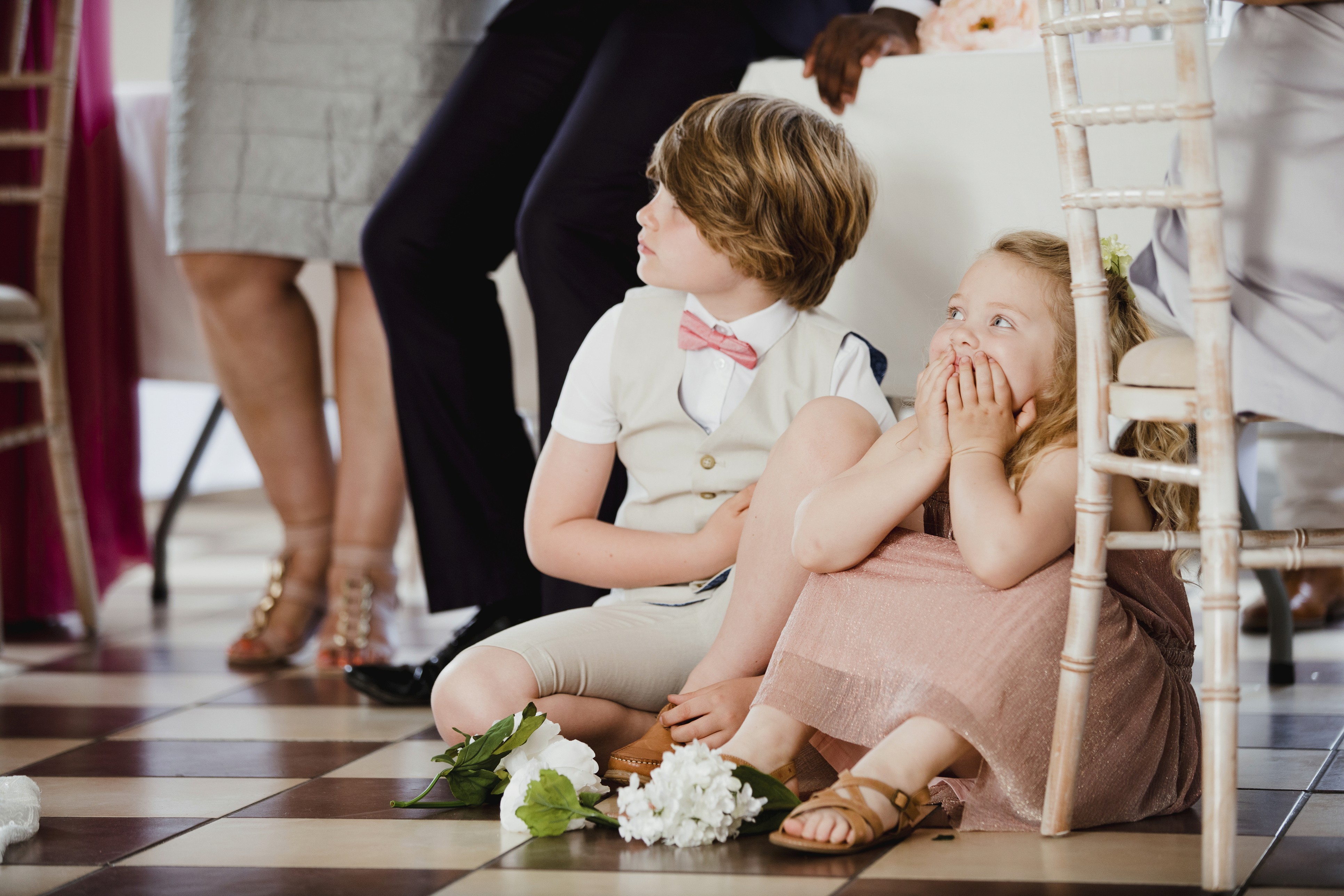 A bride and groom share a kiss surrounded by a joyful bridal party.