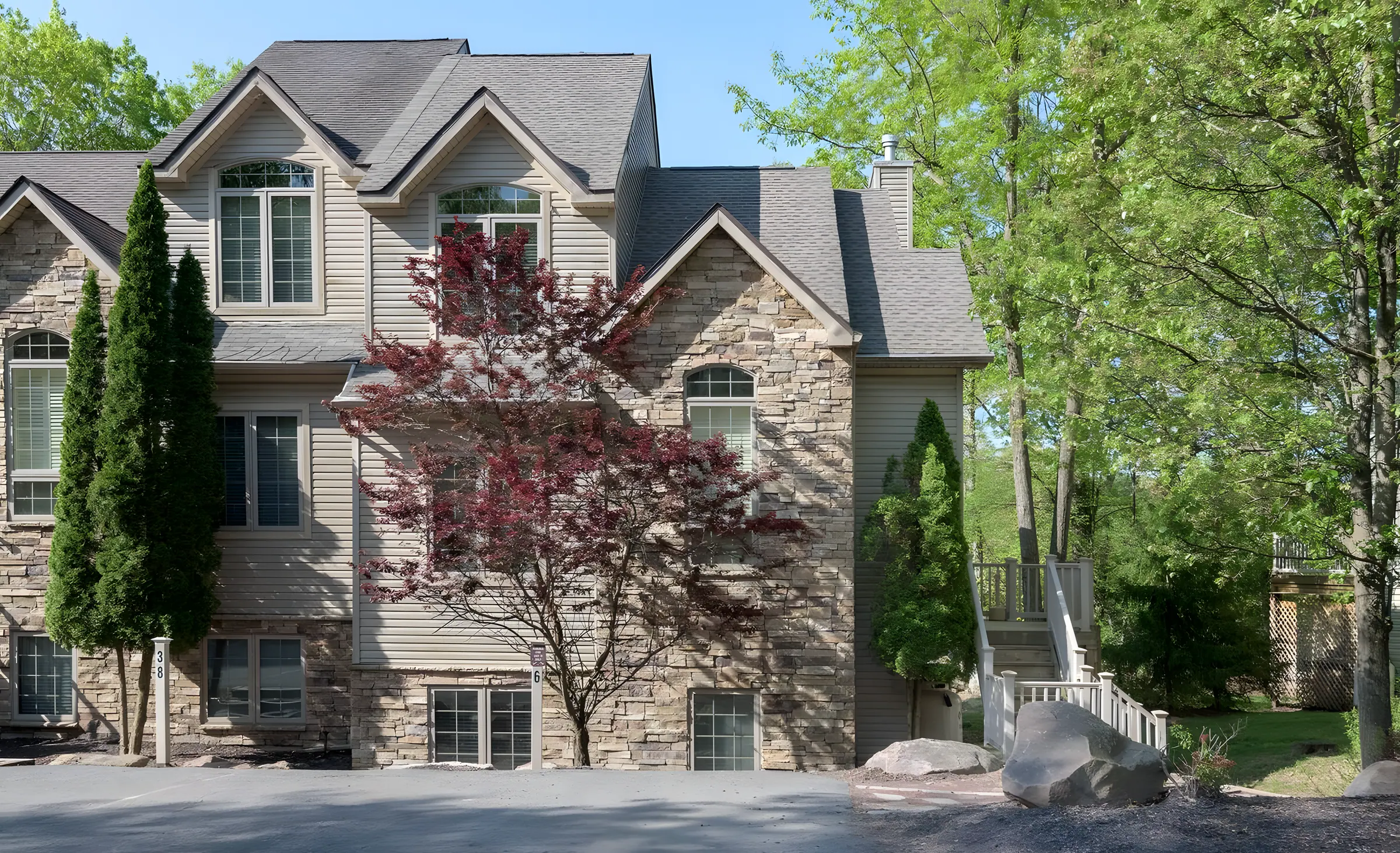 Stone-front end unit townhome with arched windows and flowering tree at Mountainwoods Memories, Big Boulder, Lake Harmony, PA