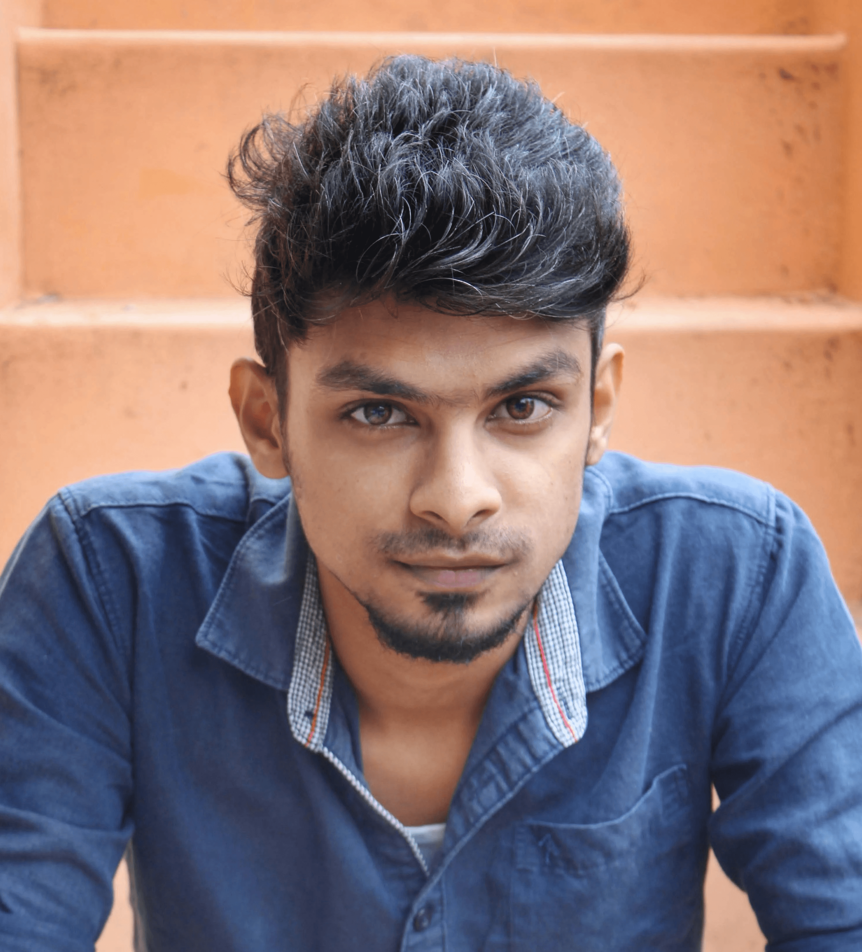 a man sitting on the ground with his hands folded