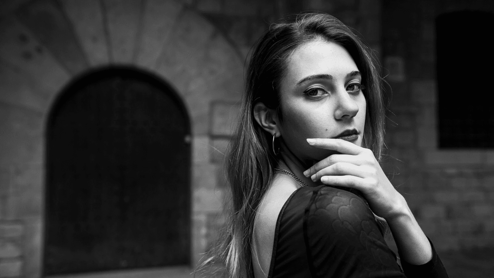Potrait of a woman with curly hair smilling towards camera