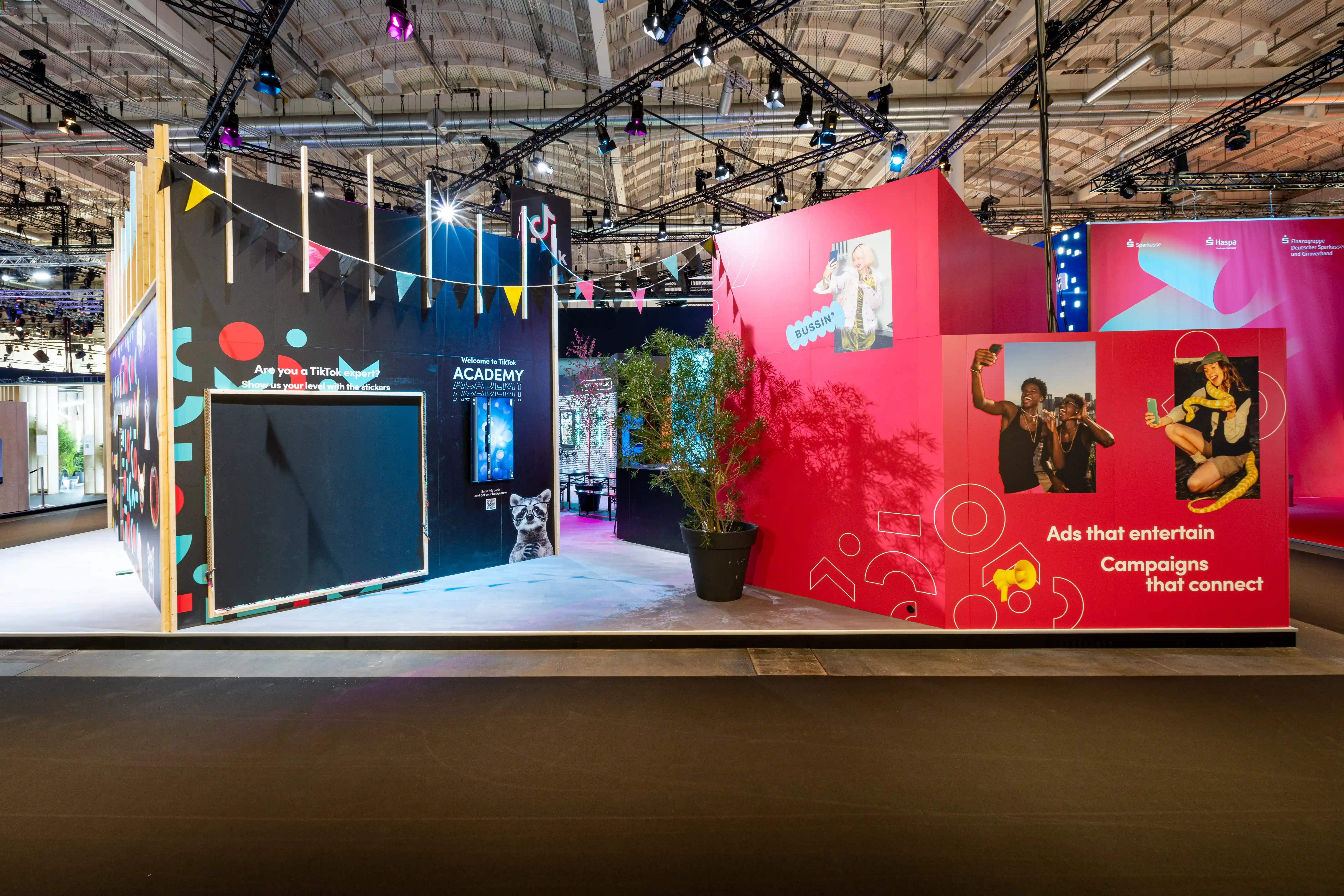 Booth walls of the TikTok stand with dark Academy chalkboard and red wall reading Ads that entertain, Campaigns that connect.