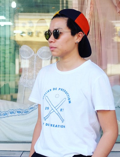 A photo of a man wearing glasses, a cap, a t-shirt with baseball bats and a ball on it.