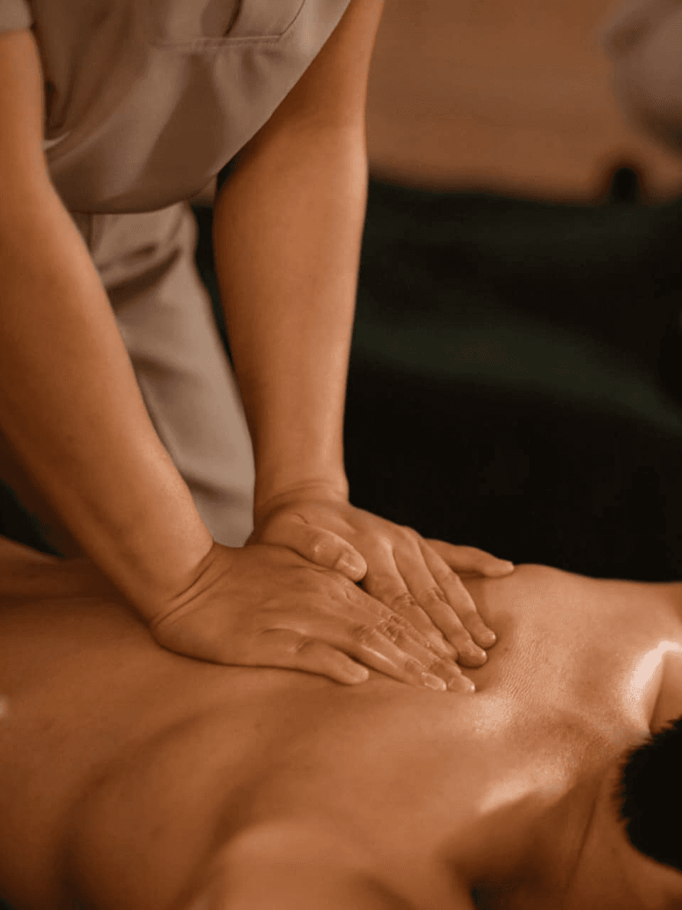 A woman relaxing in soft sunlight, surrounded by plants and warm decor, emphasizing the peaceful and rejuvenating experience of the spa.