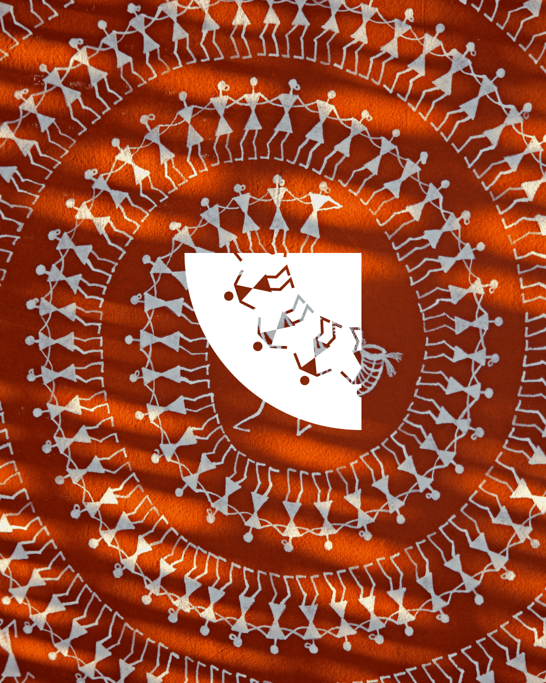 Tvarita dancing-figures motif over an orange patterned textile.