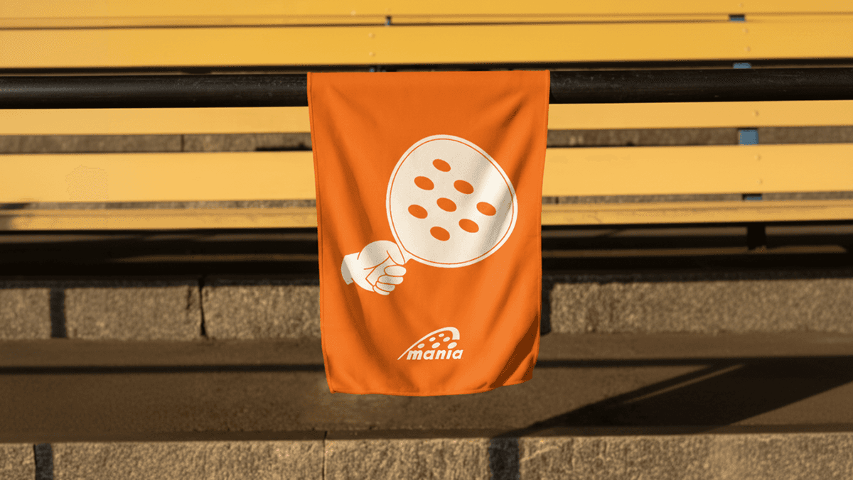 Coral colour towel with a padel racket illustration on it. Branded merchendise. 