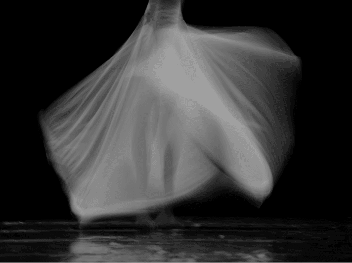 Soft-focus white fabric moving against a dark background