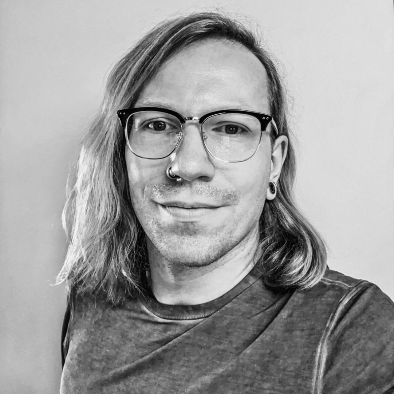 A smiling woman writing on a piece of paper in her home