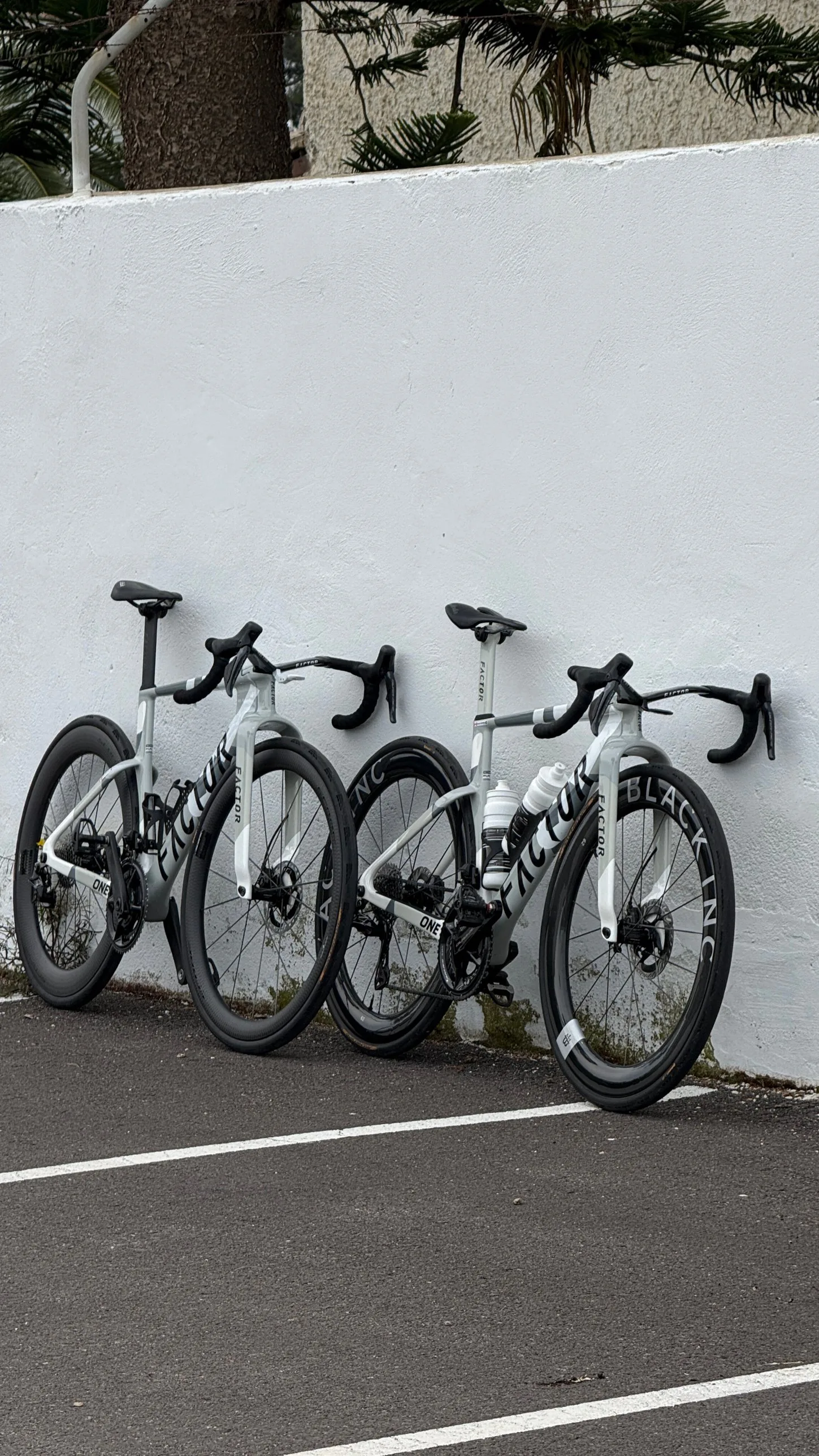 Two Factor team bikes against a white wall at the Millars camp