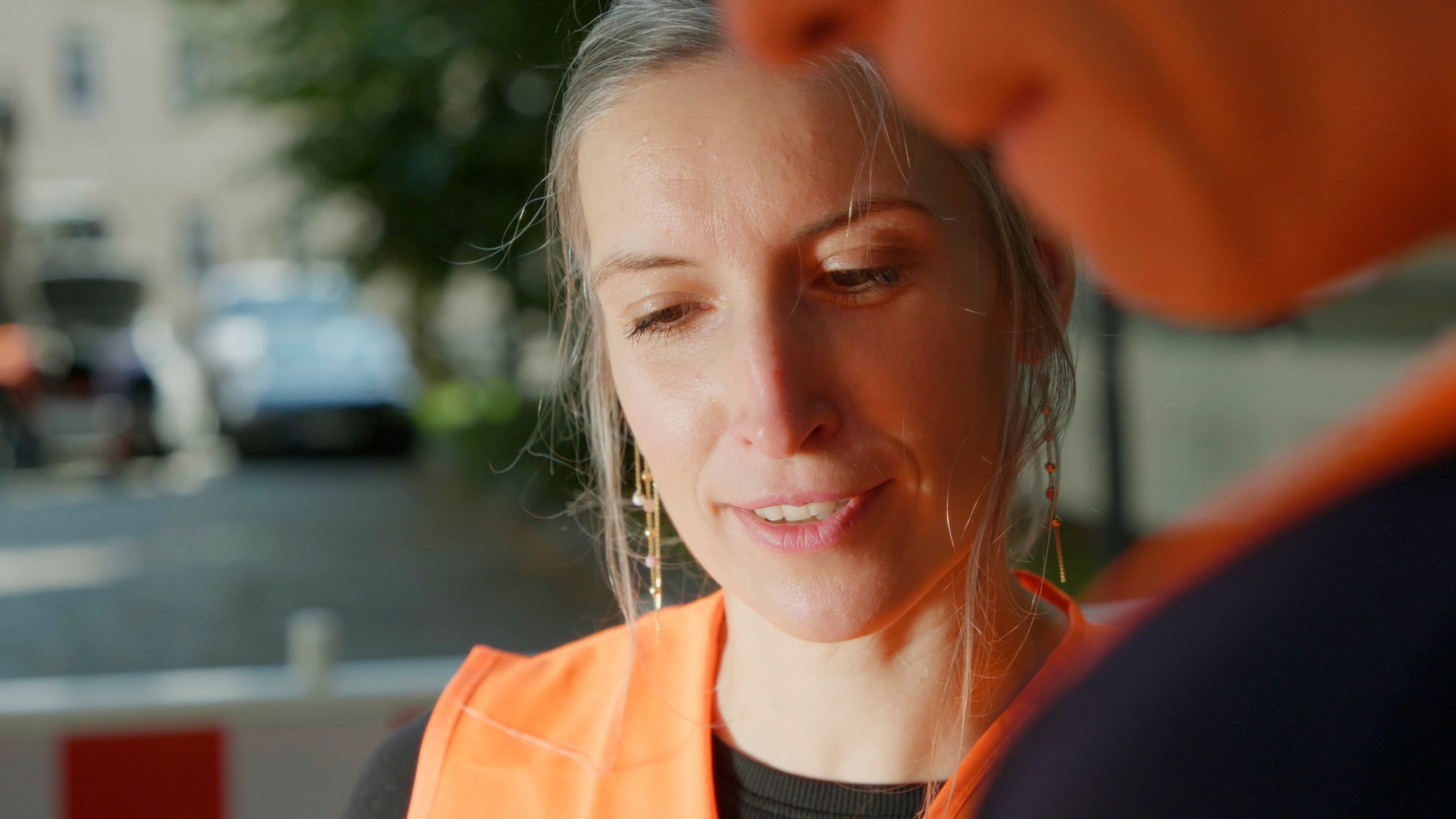 Gesicht von Frau, Orange Weste