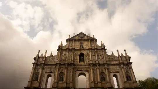 Architectural detail of the Ruins of Saint Paul's Cathedral in Macau, featuring traditional stone masonry and statues.