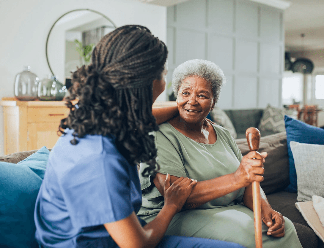 Nurse and senior woman talking in common room at assisted living facility