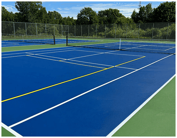 Newly resurfaced outdoor tennis courts with blue and green acrylic surface, fresh white and yellow line striping
