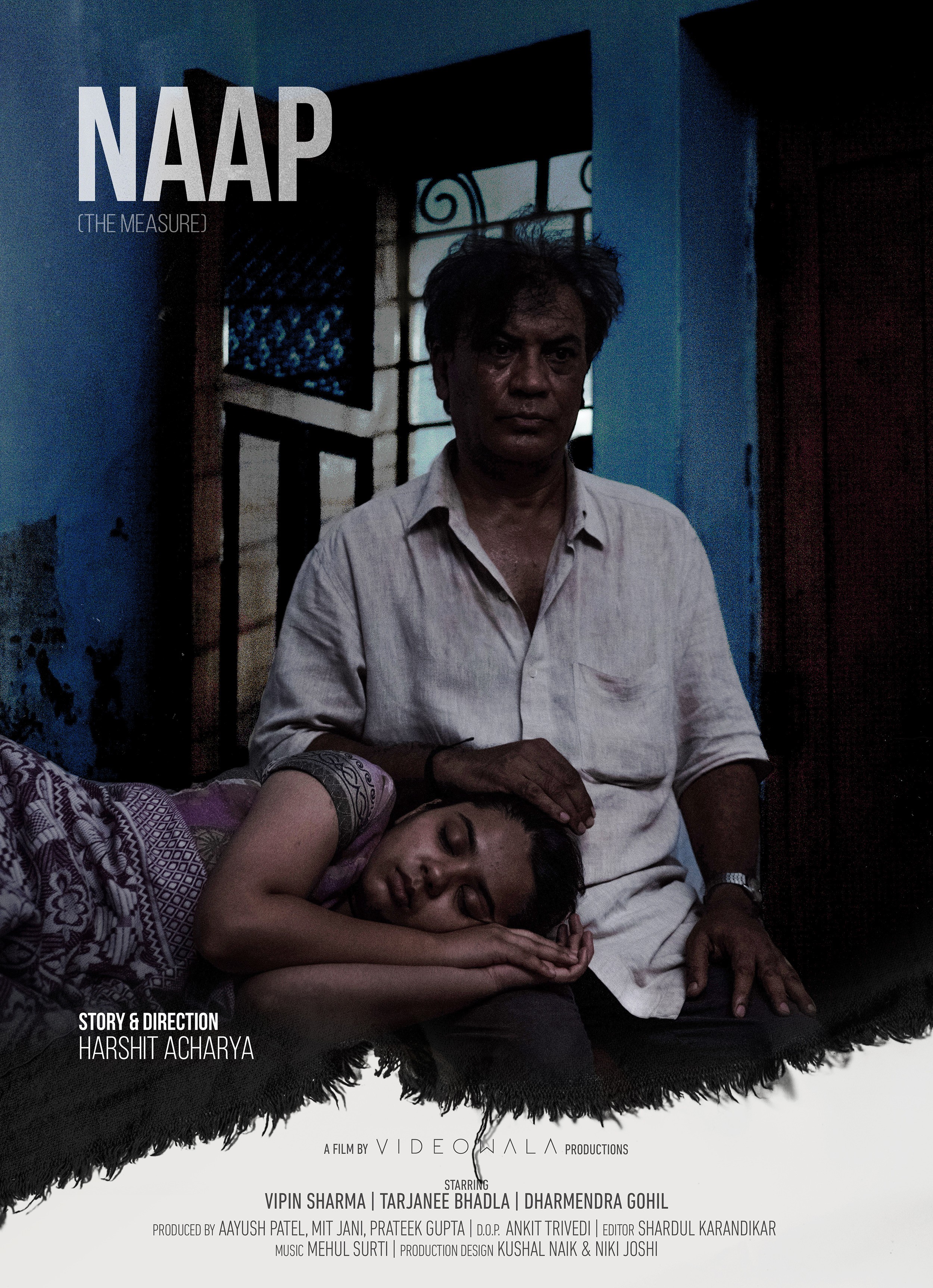 Man sitting with a woman resting her head on his lap in a dimly lit room.