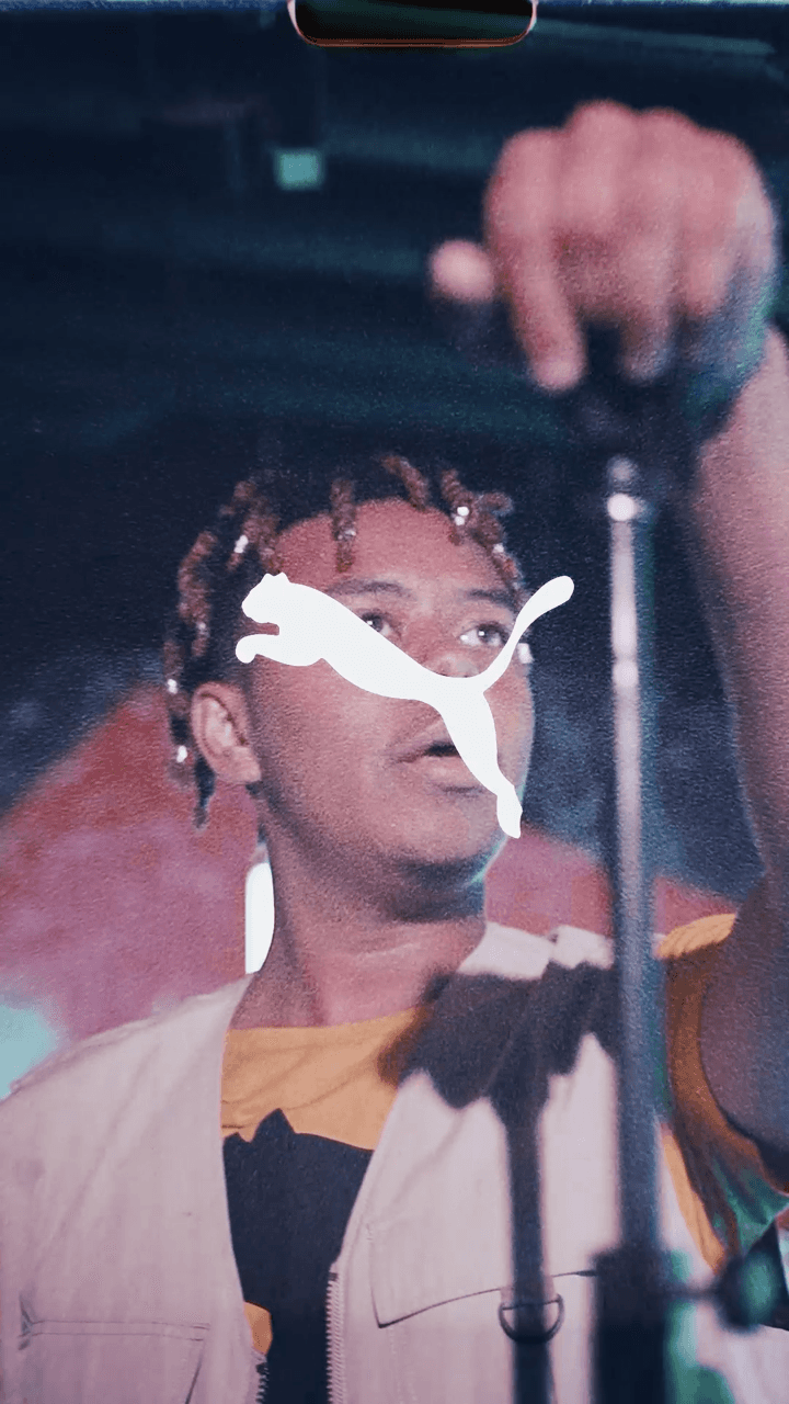 A close-up of Cordae with puma's logo on his face
