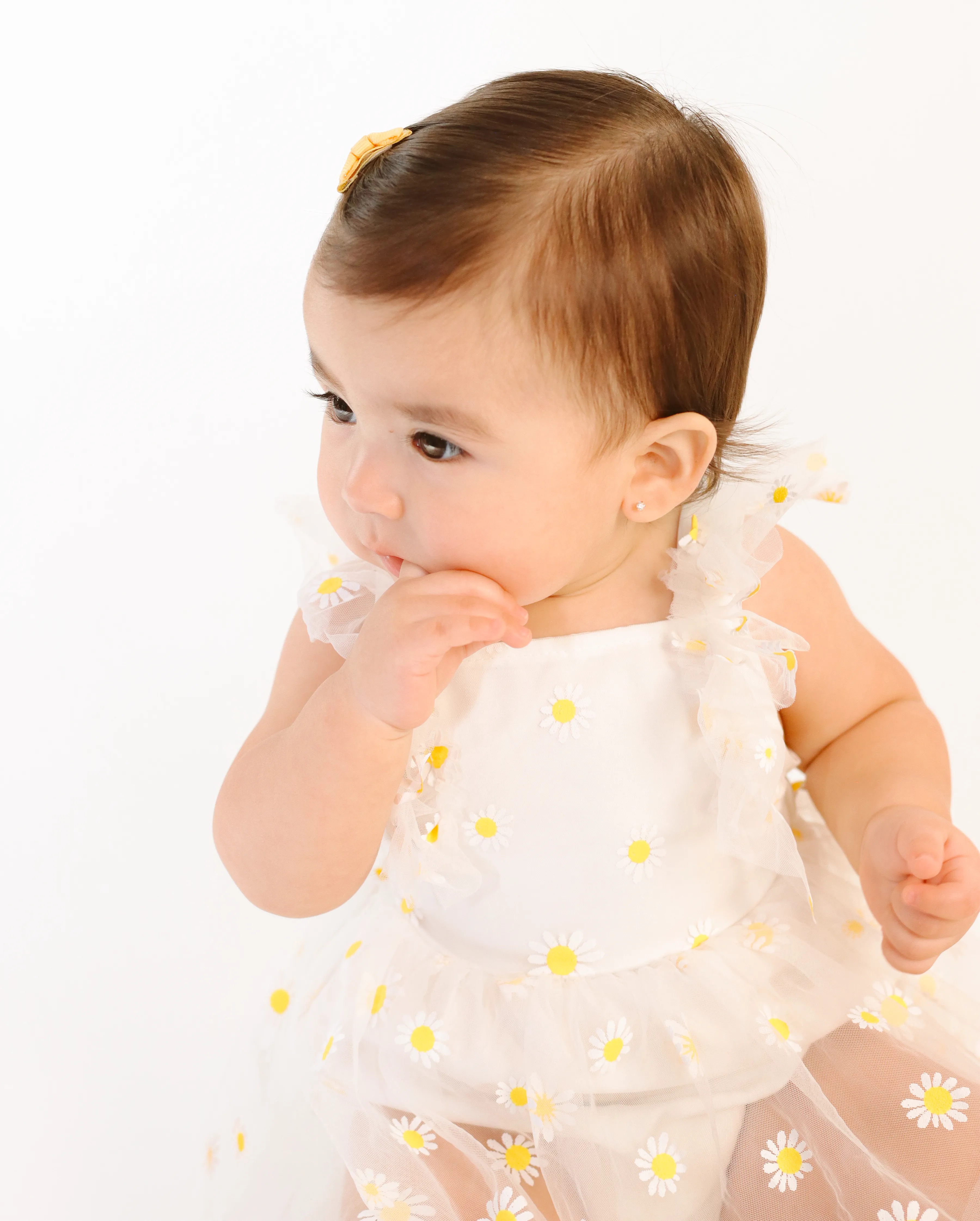 Primer plano de bebé con vestido blanco de margaritas