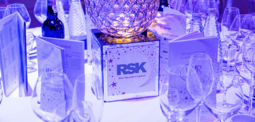 Event table setup with glasses, menys and an award.