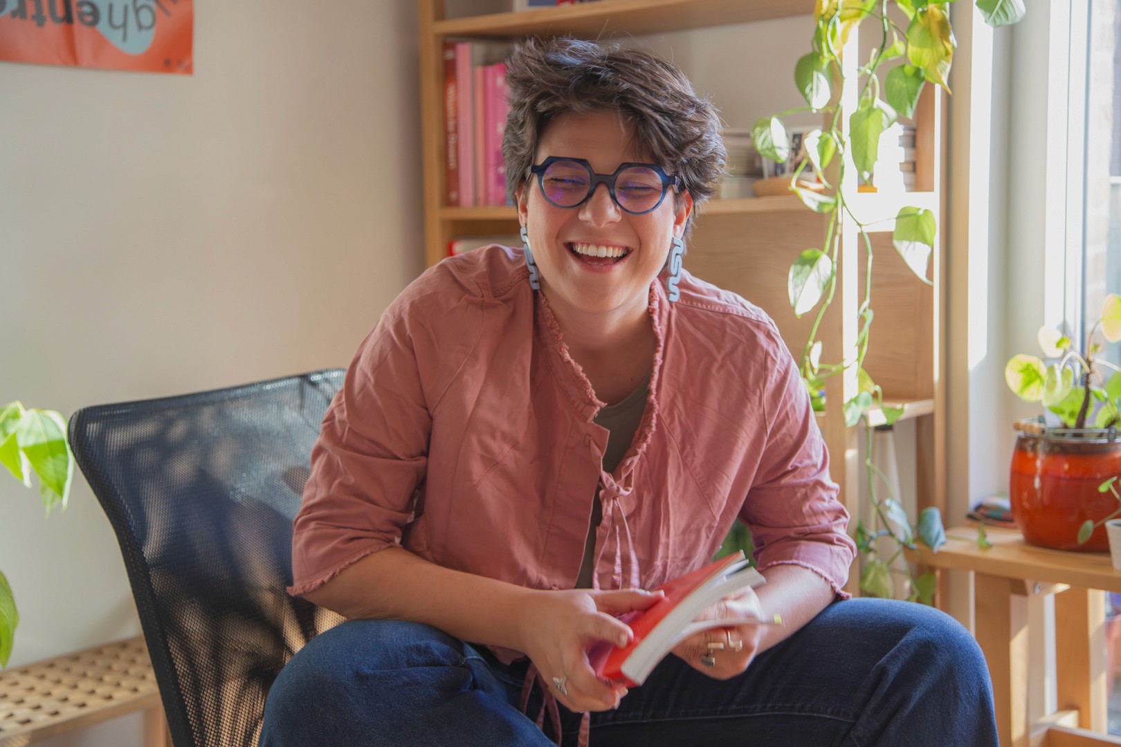 A thoughtful young person with dark hair gazes to the side, captured in soft black and white lighting.