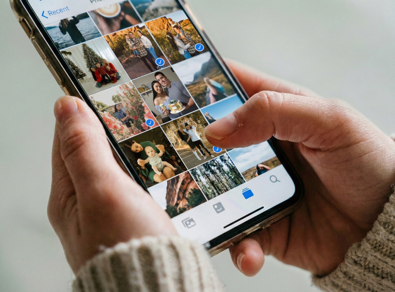 A winding road cuts through rocky terrain, surrounded by patches of green grass and illuminated by sunlight.