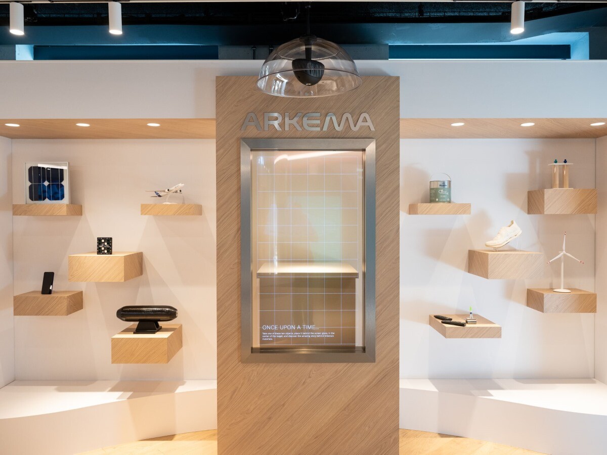 Photo of transparent screen inviting visitors to place an object behind to hear more about Arkema's innovations and products that helps producting, optimizing or recycling them.