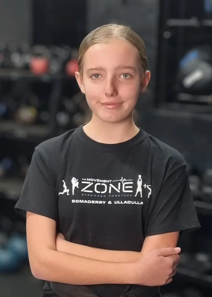 Coach Anto Newton posing in The Movement Zone shirt inside the training facility.