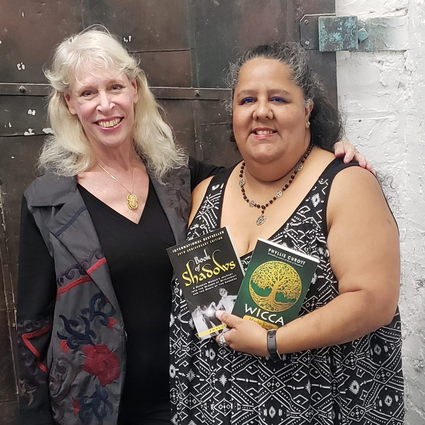 A woman with long dark hair wearing a black hijab, looking calmly at the camera against a muted background.