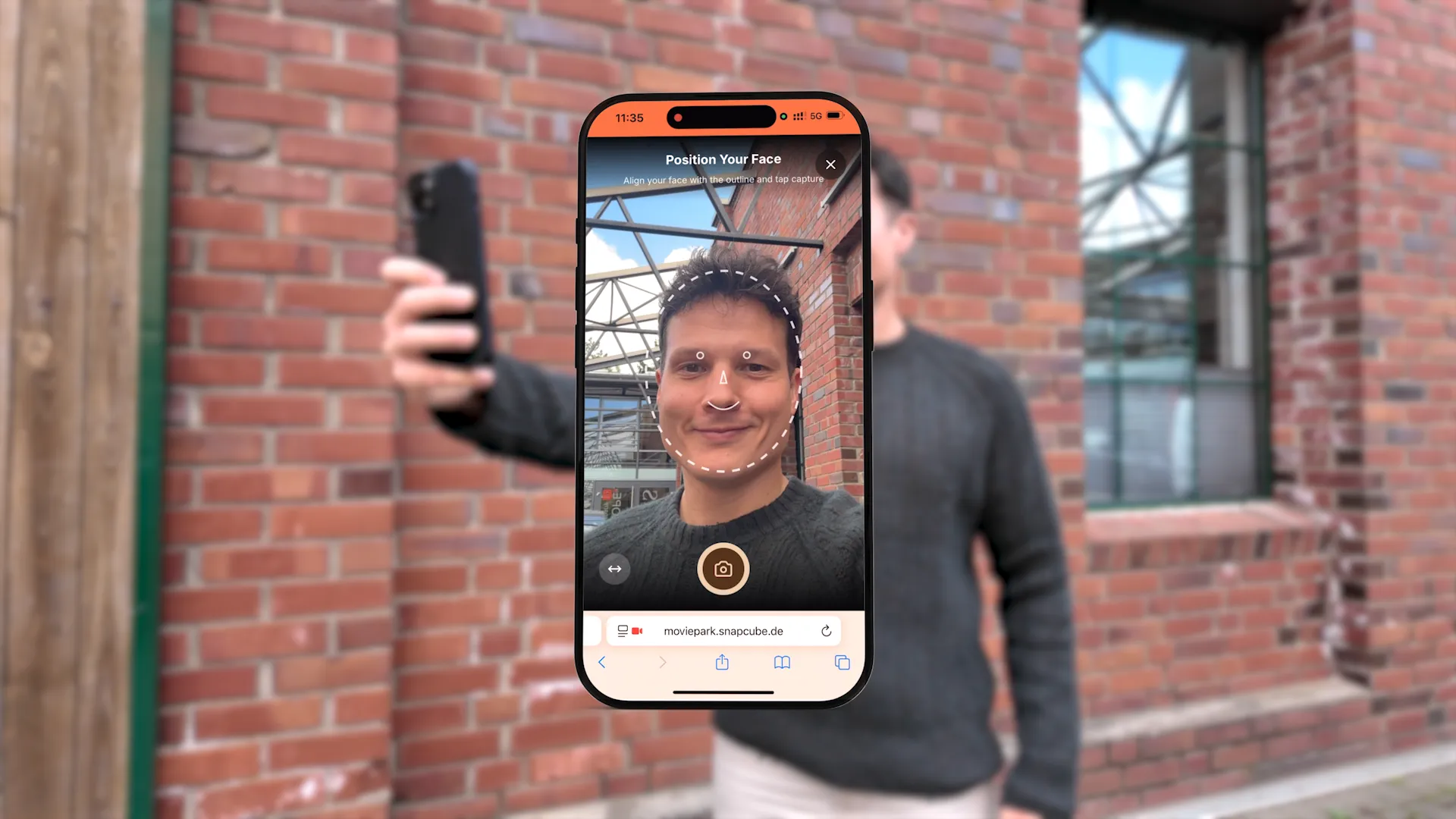 Ein Smartphone, das den ULTIDO KI-Fotoaufnahmebildschirm mit einer Gesichtskontur zeigt, während ein Gast ein Selfie macht