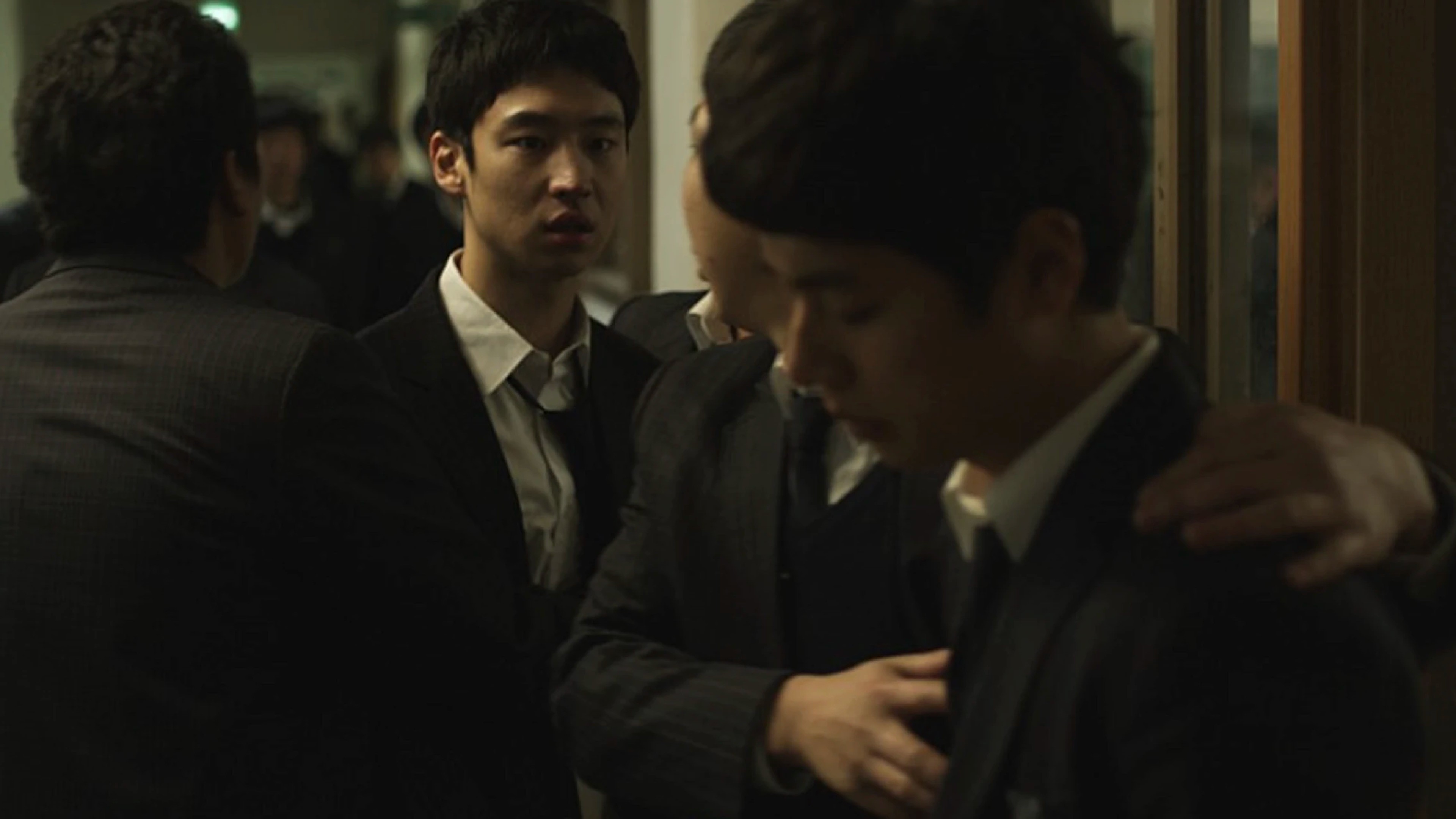 한예종 영화과 2차 이야기구성 졸업식 실종 주제 이미지. 정장 차림의 세 남성이 서로를 위로하는 장면