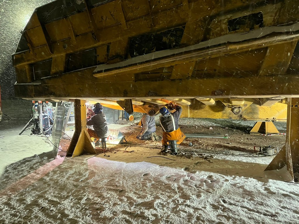 Mining heavy equipment dump truck body under aftermarket repair.