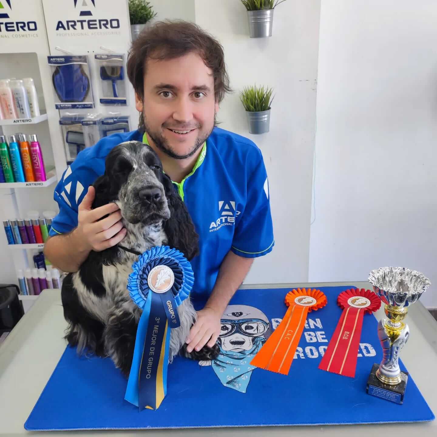 Carlos Romera mostrando a su perro y algunos premios que ha ganado
