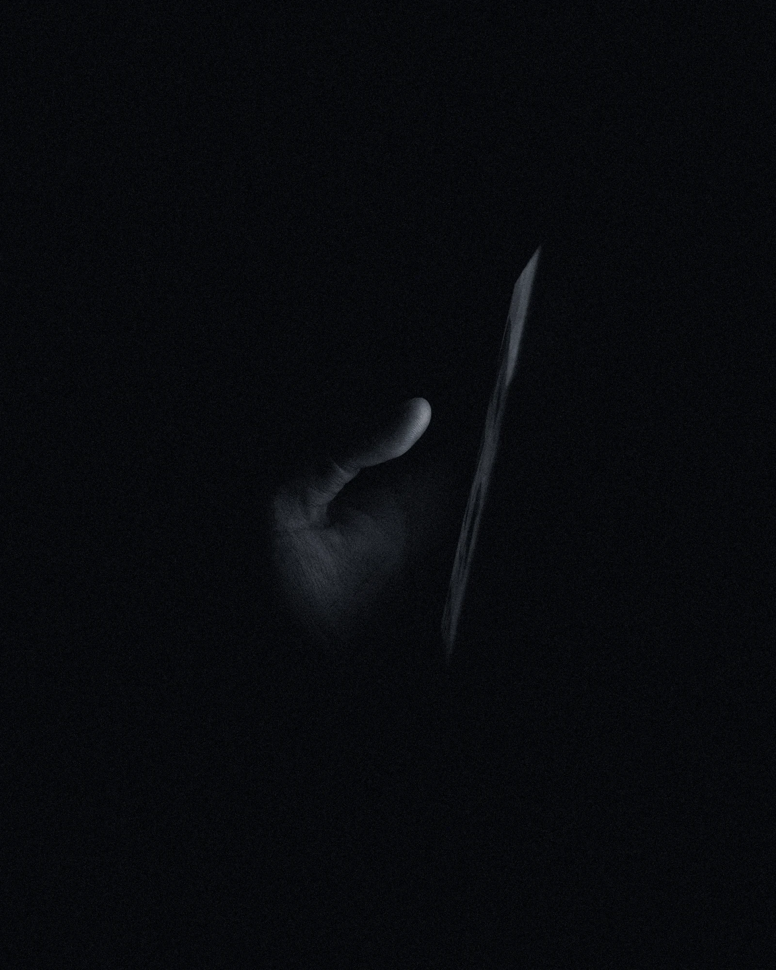 A hand holding a glowing phone in the dark