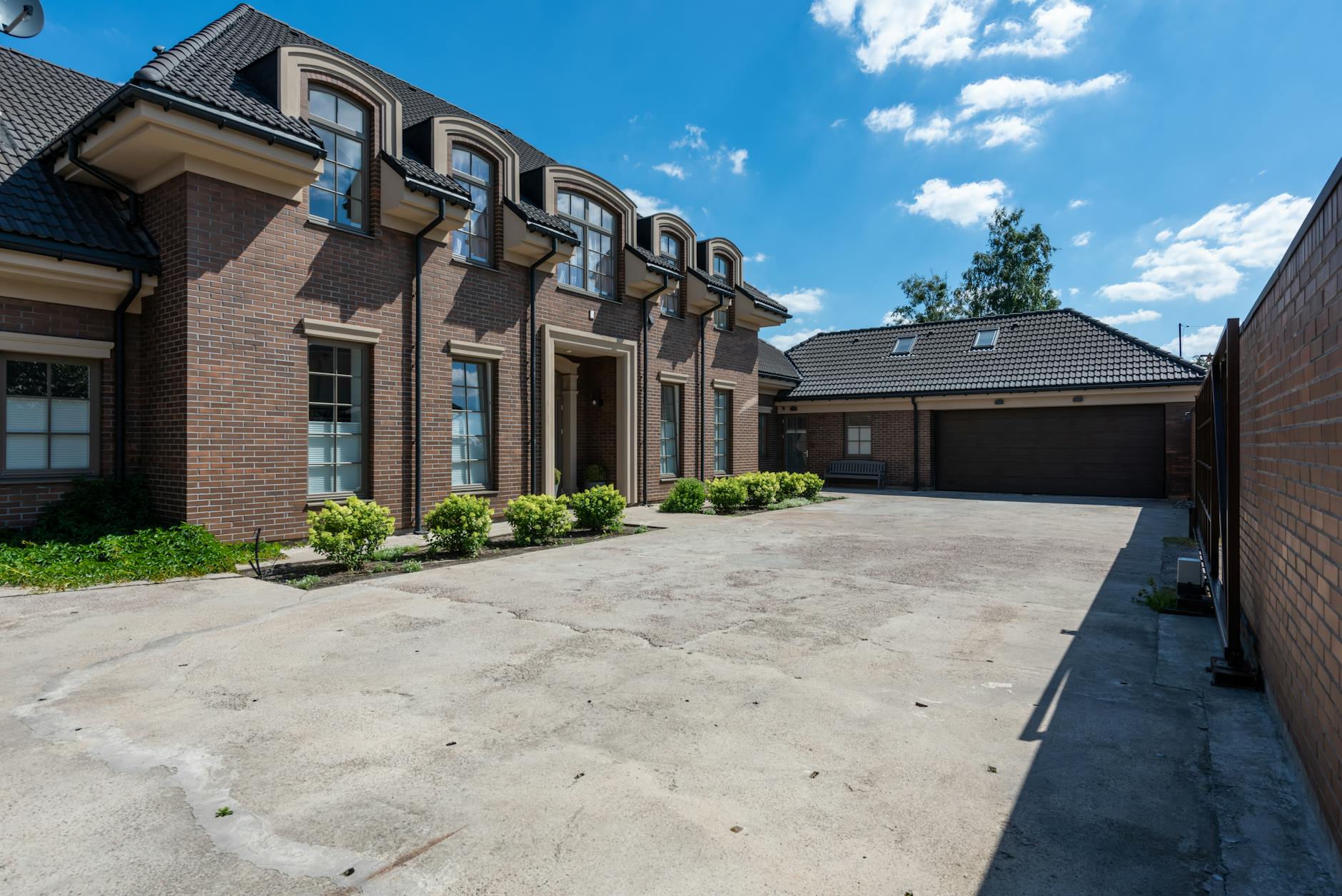 Two architects in hard hats examining the exterior of a modern white building with large windows